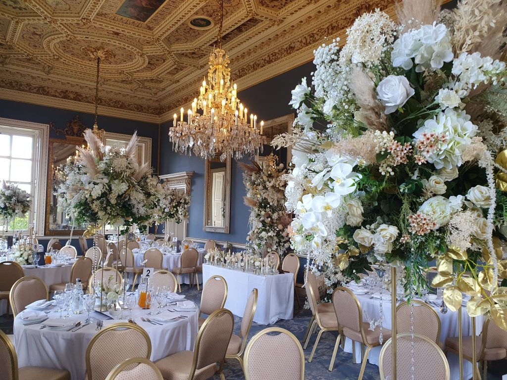 A room in a stately home, dressed with wedding decorations, flowers and luxury table settings.